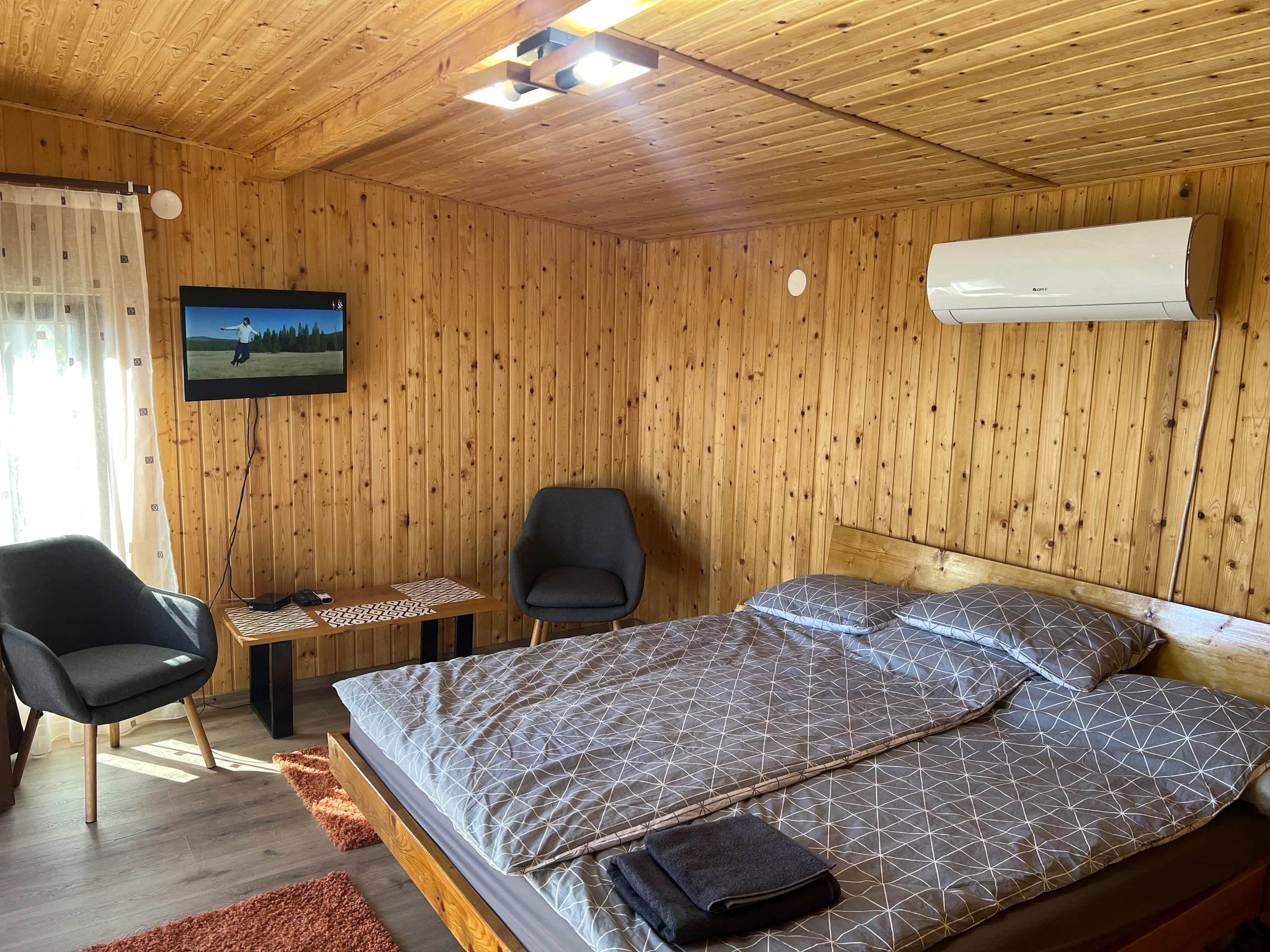 Main bedroom with simple linens and a landscape view